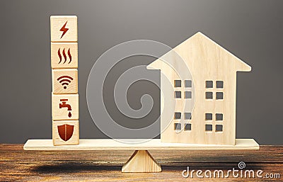 House and blocks with utilities public service symbols on scales. Availability of bill payment Stock Photo