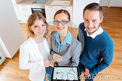 House broker and clients in new apartment looking into camera Stock Photo