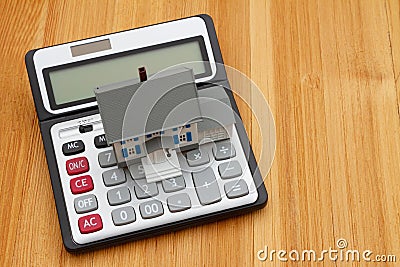 A house and calculator on a wood desk Stock Photo