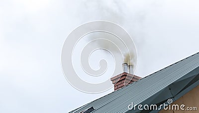 House chimney with flying smoke Stock Photo