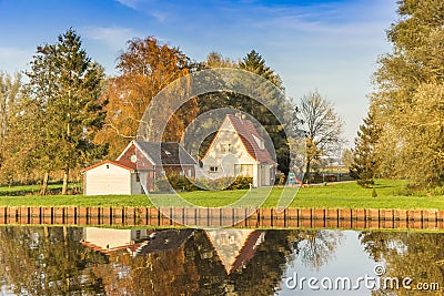 House and colorful trees reflected in the Winschoterdiep canal in Groningen Stock Photo