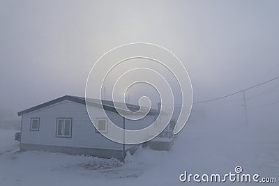 House almost completely gone under blizzard conditions in the Canadian Arctic Stock Photo