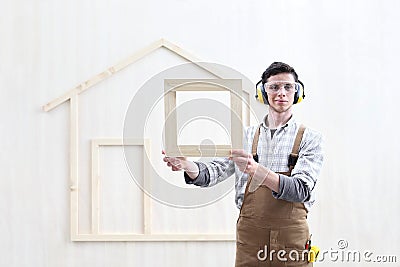 House construction renovation concept handyman carpenter worker man show the model of wooden house Stock Photo