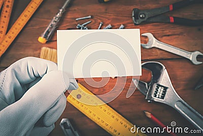 House construction and repair services - worker holding blank business card over work tools Stock Photo