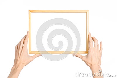 House decoration and Photo Frame topic: human hand holding a wooden picture frame isolated on a white background in the studio fir Stock Photo