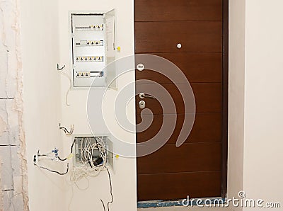 House entrance door with surface mounted open electric meter box with residual current device or RCD Stock Photo