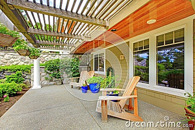 House exterior. View of cozy covered walkout deck with concrete floor. Stock Photo