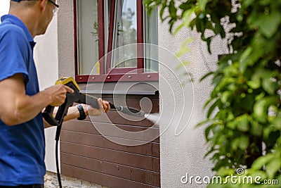 House facade cleaning service. man washing wall with high pressure washer Stock Photo