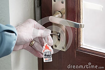 House fire kills symbol on key ring and senior person hand with key unlocking door to escape Stock Photo