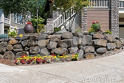 House Front Yard Landscaping with Rock Retaining Wall Stock Photo