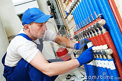 Plumber work. Installing collector for warm water underfloor heating system Stock Photo