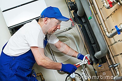 Plumber work. Installing collector for warm water underfloor heating system Stock Photo