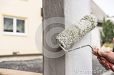 House improvement men with paint roller painting column Stock Photo