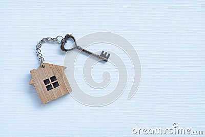 House key in heart shape with home keyring on old wood background Stock Photo