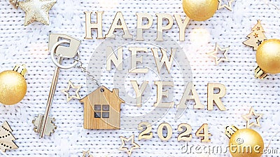 House key with keychain cottage on cozy festive knitted background with stars, bokeh. Happy New Year 2024 wooden letters, greeting Stock Photo