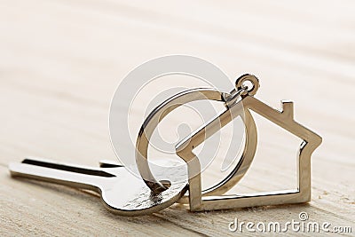 House key with a keychain on wooden desk concept for real estate Stock Photo