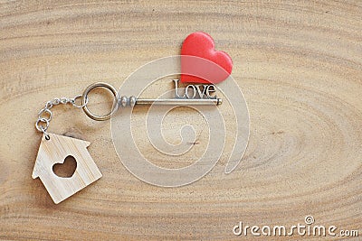House keyring and love shape key on vintage wooden table. Decorated with mini heart as sweet gift for lover or family member. Home Stock Photo