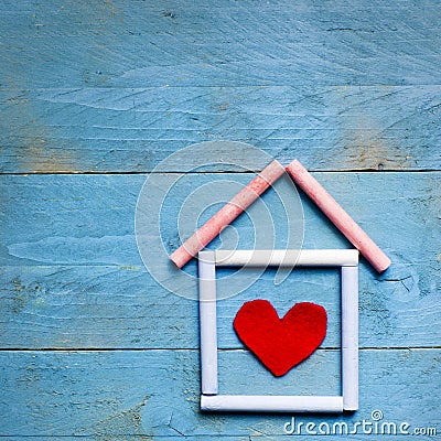 House made of chalk with red heart in it on blue wooden background. Sweet home concept. Mortgage Stock Photo