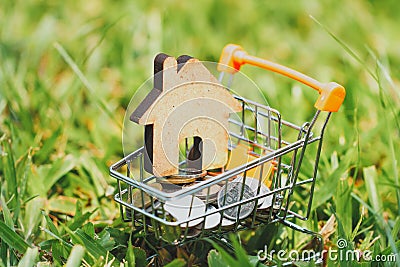 House in mini shopping cart with stack of coins money for residential investment. Stock Photo