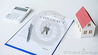 House model, calculator and house key lying on real estate contract, home loan and investment concept Stock Photo