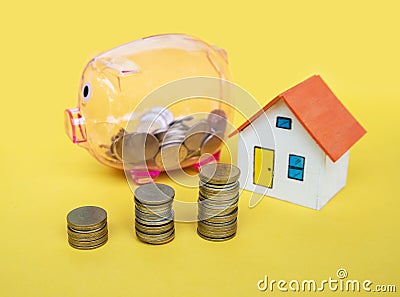 House model and coin money on yellow background Stock Photo