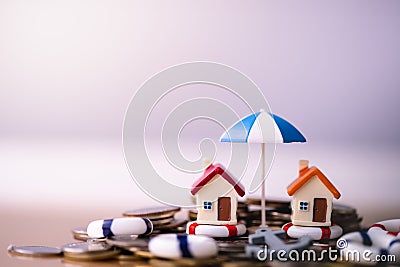 House model in lifebuoys on coins stack. Stock Photo