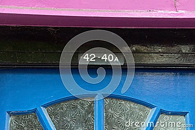 The house number 42 and 40A on a black, blue, and purple painted door Editorial Stock Photo