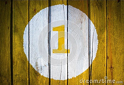 House number or calendar date in white circle on yellow toned wooden door background. Number one 1 Stock Photo