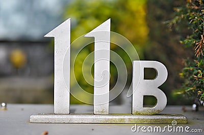 A house number plaque, showing the number eleven B 11 b Stock Photo