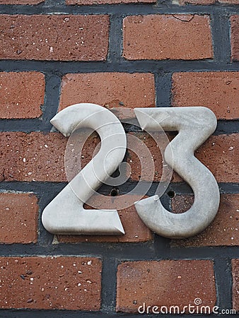 House number 23, white numbers on a clinker wall Stock Photo
