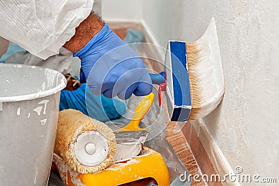 House painter at work painting a wall with a brush Stock Photo