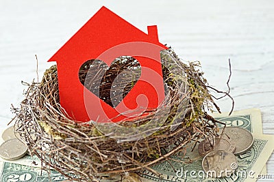 House paper with heart in nest on money background - Love for home, home insurance concept Stock Photo