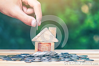 House placed on coins. hand that is coin down the house. Indicates the growth of home and finance. Stock Photo