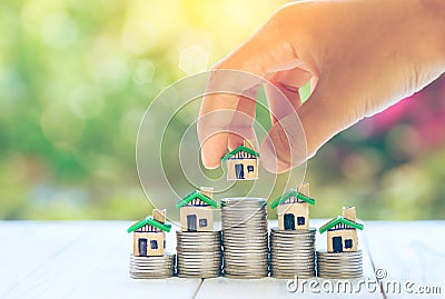 House placed on coins Men`s hand is planning savings money of coins to buy a home concept concept for property ladder, mortgage a Stock Photo