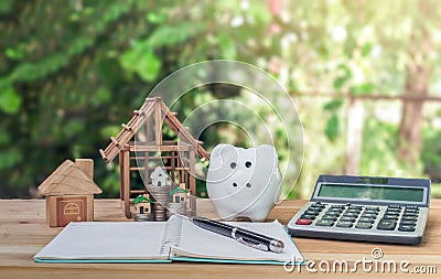 House placed on table. pen with notebook Coins and piggy banks on the table. concept planning savings money of coins to buy a home Stock Photo