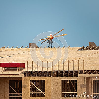 House roof. Roofing construction. Roofer using air nail. Roofing tiles of the new roof under construction building Stock Photo