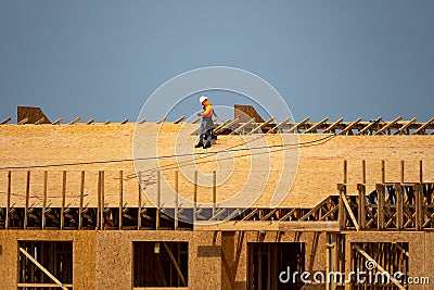 House roof. Roofing construction. Roofer using air nail. Roofing tiles of the new roof under construction building Stock Photo