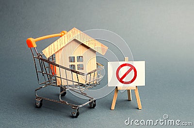 House in the shopping cart and the sign of the ban NO. Inaccessible and expensive housing. Seizure and freezing of assets Stock Photo