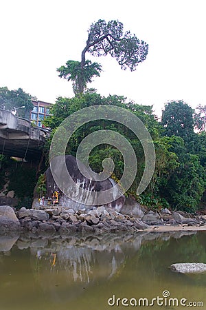 The house of spirits next to a large stone under the bridge. Editorial Stock Photo