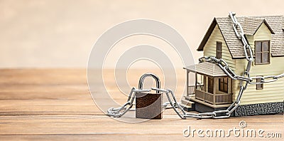 House tied with a chain and a closed lock. Concept ban on the sale of real estate, house arrest. Template Copy space for Stock Photo