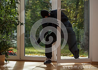 Burglar entering through the balcony window Stock Photo