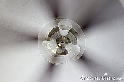 Classic polished brass ceiling fan with light in motion. Stock Photo