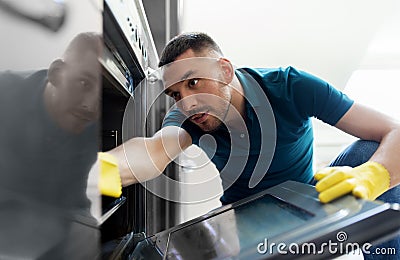 Man with rag cleaning inside oven at home kitchen Stock Photo