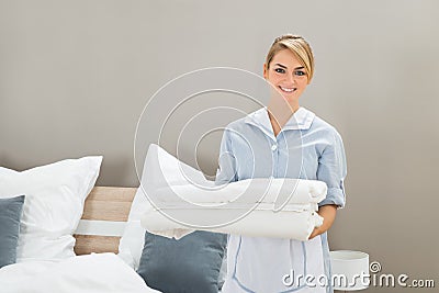 Housekeeper holding stack of sheet Stock Photo