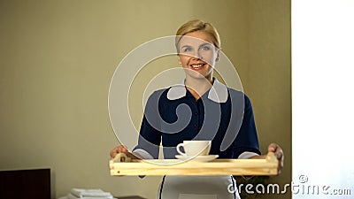 Housemaid bringing tray with coffee, good service, 5star hotel room booking Stock Photo