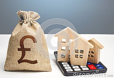 Houses on a calculator and british pound sterling money bag. Buying and selling. Real estate valuation. Building maintenance. Stock Photo