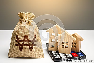 Houses on a calculator and south korean won money bag. Buying and selling. Real estate valuation. Building maintenance. Mortgage. Stock Photo