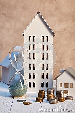 Houses models, coins and hourglass on Stock Photo