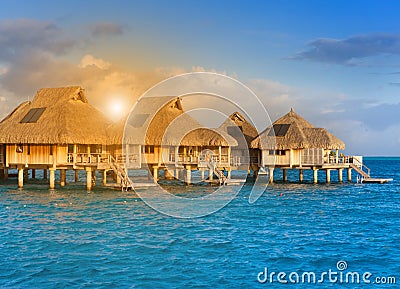 Houses on piles on water at the time sunset Stock Photo