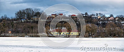 Houses on a rock on the other side of a frozen river Editorial Stock Photo